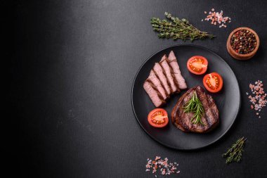 Lezzetli taze biftek, esrarlı baharatlar ve çimento kaplı otlar. Izgara yemek.