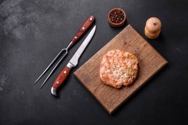 Lezzetli taze ızgara hindi eti. Baharat ve otlarla birlikte koyu beton arka planda.