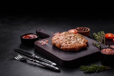 Lezzetli taze ızgara hindi eti. Baharat ve otlarla birlikte koyu beton arka planda.