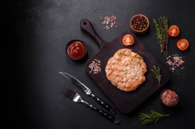 Lezzetli taze ızgara hindi eti. Baharat ve otlarla birlikte koyu beton arka planda.