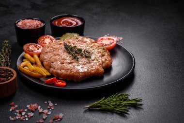 Lezzetli taze ızgara hindi eti. Baharat ve otlarla birlikte koyu beton arka planda.