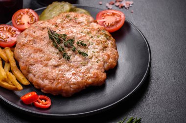 Lezzetli taze ızgara hindi eti. Baharat ve otlarla birlikte koyu beton arka planda.