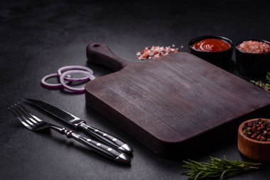 Lezzetli taze ızgara hindi eti. Baharat ve otlarla birlikte koyu beton arka planda.