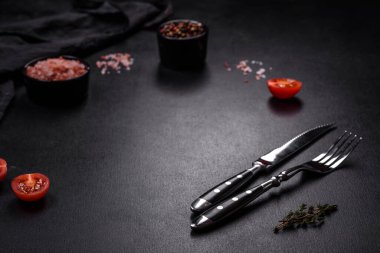 Lezzetli ızgara domuz bifteği, baharatlar ve otlar ahşap bir kesim tahtasının üzerinde.