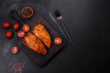 Lezzetli ızgara tavuk filetosu. Baharat ve otlarla kaplı. Koyu beton bir arka plan.