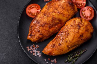 Lezzetli ızgara tavuk filetosu. Baharat ve otlarla kaplı. Koyu beton bir arka plan.