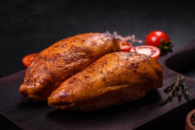 Lezzetli ızgara tavuk filetosu. Baharat ve otlarla kaplı. Koyu beton bir arka plan.