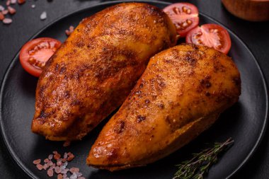 Lezzetli ızgara tavuk filetosu. Baharat ve otlarla kaplı. Koyu beton bir arka plan.