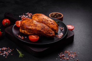 Lezzetli ızgara tavuk filetosu. Baharat ve otlarla kaplı. Koyu beton bir arka plan.