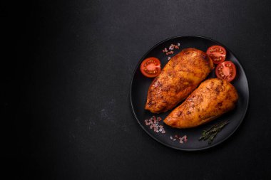 Lezzetli ızgara tavuk filetosu. Baharat ve otlarla kaplı. Koyu beton bir arka plan.