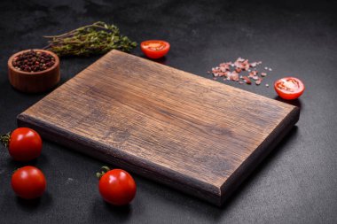 Ürünler, tuz, baharatlar ve otlar karanlık boş bir masada. Evde yemek yapmaya hazırlanıyorum.