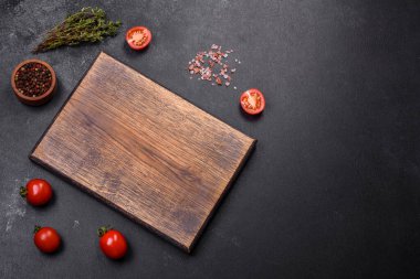 Ürünler, tuz, baharatlar ve otlar karanlık boş bir masada. Evde yemek yapmaya hazırlanıyorum.