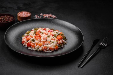 Siyah tabakta sebzeli, baharatlı ve otlu lezzetli taze risotto.