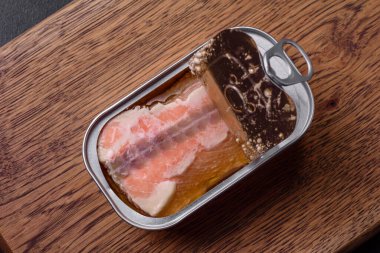 Koyu beton arka planda anahtarı olan teneke ya da alüminyum dikdörtgen konserve somon konservesi