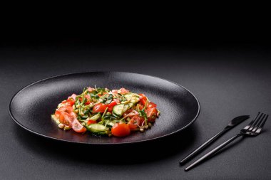 Lezzetli taze salata, domates, biber, salatalık, mikro yeşil ve siyah seramik tabakta filizlenmiş mung fasulyesi.