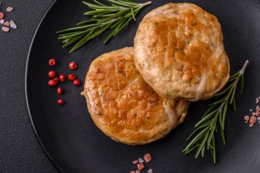 Grilled meatballs with spices and herbs or crepinette on a dark concrete background