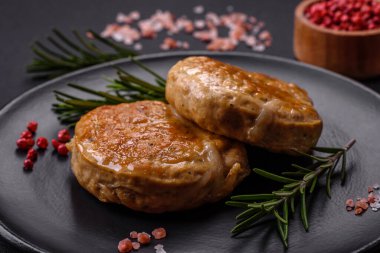 Grilled meatballs with spices and herbs or crepinette on a dark concrete background