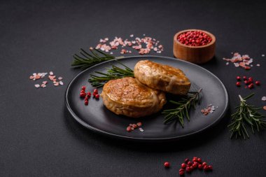 Grilled meatballs with spices and herbs or crepinette on a dark concrete background