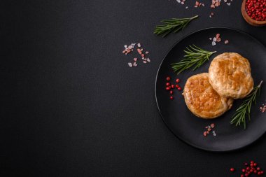 Grilled meatballs with spices and herbs or crepinette on a dark concrete background