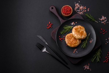 Grilled meatballs with spices and herbs or crepinette on a dark concrete background