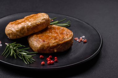 Grilled meatballs with spices and herbs or crepinette on a dark concrete background