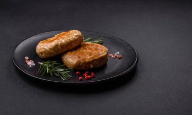 Grilled meatballs with spices and herbs or crepinette on a dark concrete background