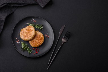Grilled meatballs with spices and herbs or crepinette on a dark concrete background