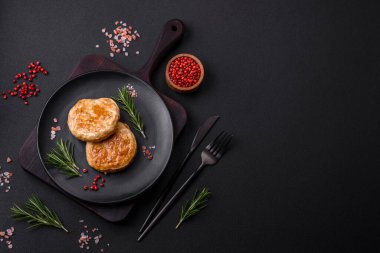 Grilled meatballs with spices and herbs or crepinette on a dark concrete background