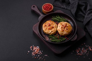 Grilled meatballs with spices and herbs or crepinette on a dark concrete background
