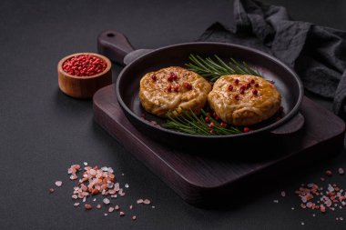 Grilled meatballs with spices and herbs or crepinette on a dark concrete background