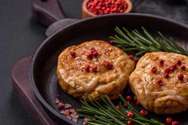 Grilled meatballs with spices and herbs or crepinette on a dark concrete background