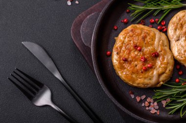 Grilled meatballs with spices and herbs or crepinette on a dark concrete background