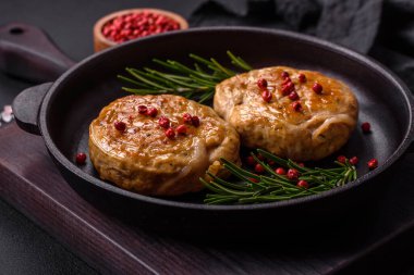 Grilled meatballs with spices and herbs or crepinette on a dark concrete background