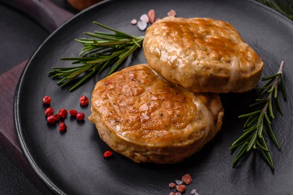 Grilled meatballs with spices and herbs or crepinette on a dark concrete background