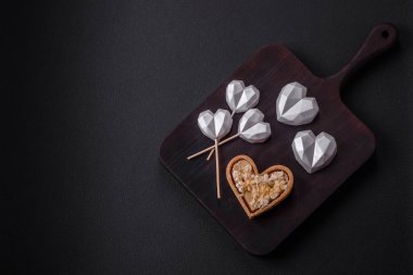 Beautiful tasty sweet candies in gray color on a dark concrete background. Sweets for valentine's day