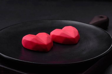 Delicious sweet heart shaped chocolate candies on a dark concrete background. Valentines day celebration
