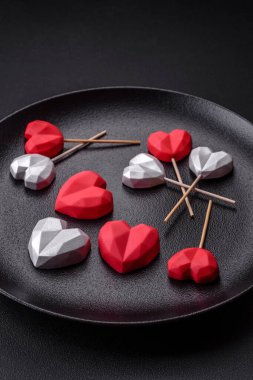 Delicious sweet heart shaped chocolate candies on a dark concrete background. Valentines day celebration