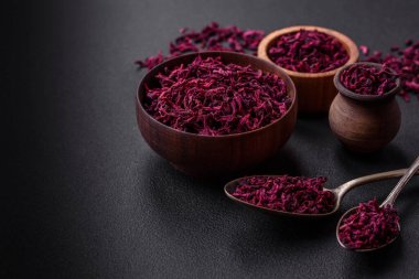Dried beets in small slices in a wooden bowl on a black concrete background. Asian cuisine