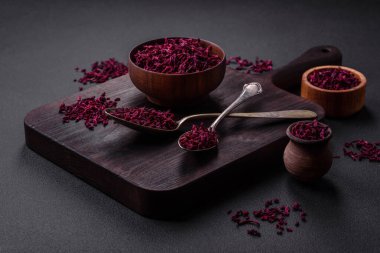 Dried beets in small slices in a wooden bowl on a black concrete background. Asian cuisine