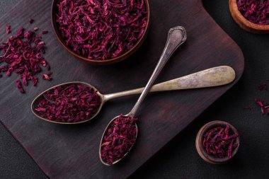 Dried beets in small slices in a wooden bowl on a black concrete background. Asian cuisine
