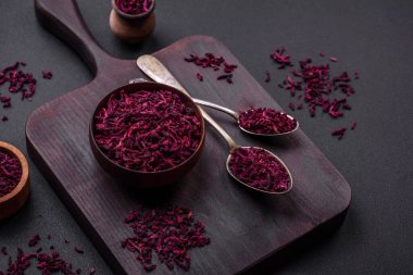 Dried beets in small slices in a wooden bowl on a black concrete background. Asian cuisine