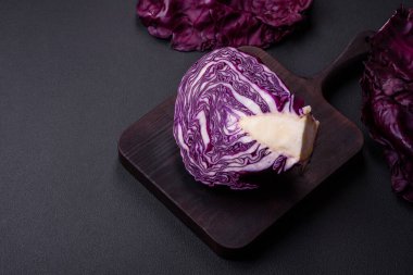 Fresh beautiful red cabbage with textured leaves on a dark concrete background. Vegetarian cooking