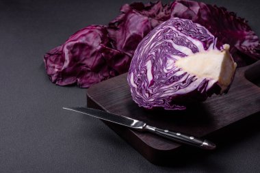 Fresh beautiful red cabbage with textured leaves on a dark concrete background. Vegetarian cooking