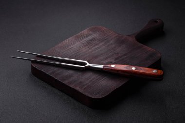 Metal kitchen fork on a dark textured concrete background. Cutlery, preparation for dinner