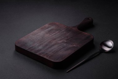 Empty metal spoon on dark textured concrete background. Cutlery, preparation for dinner