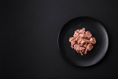 Siyah seramik tabakta koyu beton zeminde nefis konserve ton balığı eti. Sağlıklı yemek hazırlığı