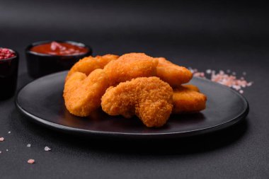 Delicious fresh crispy chicken nuggets on a dark concrete background. Unhealthy food, fast food