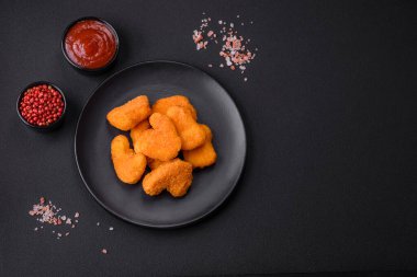 Delicious fresh crispy chicken nuggets on a dark concrete background. Unhealthy food, fast food
