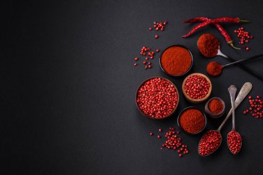 Spice smoked paprika in the form of powder in bowls and spoons on a dark concrete background. Asian cuisine ingredients