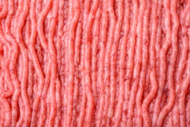 Raw beef or pork mince with salt spices and herbs on a wooden cutting board on a dark concrete background